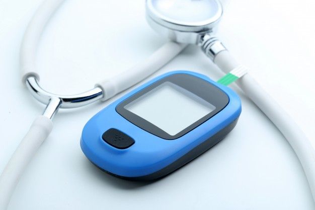 medidor de glicose no sangue e estetoscopio no fundo branco_1387 238